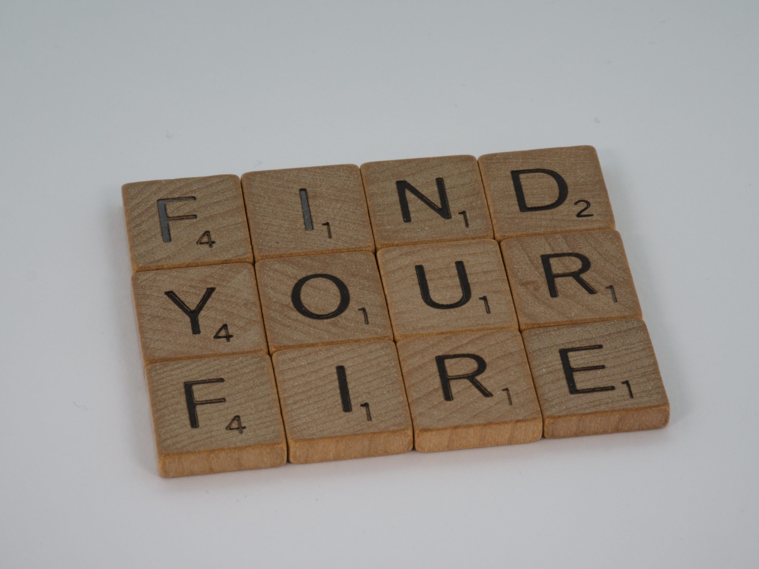 Wooden scrabble letters making out the words 'FIND YOUR FIRE'